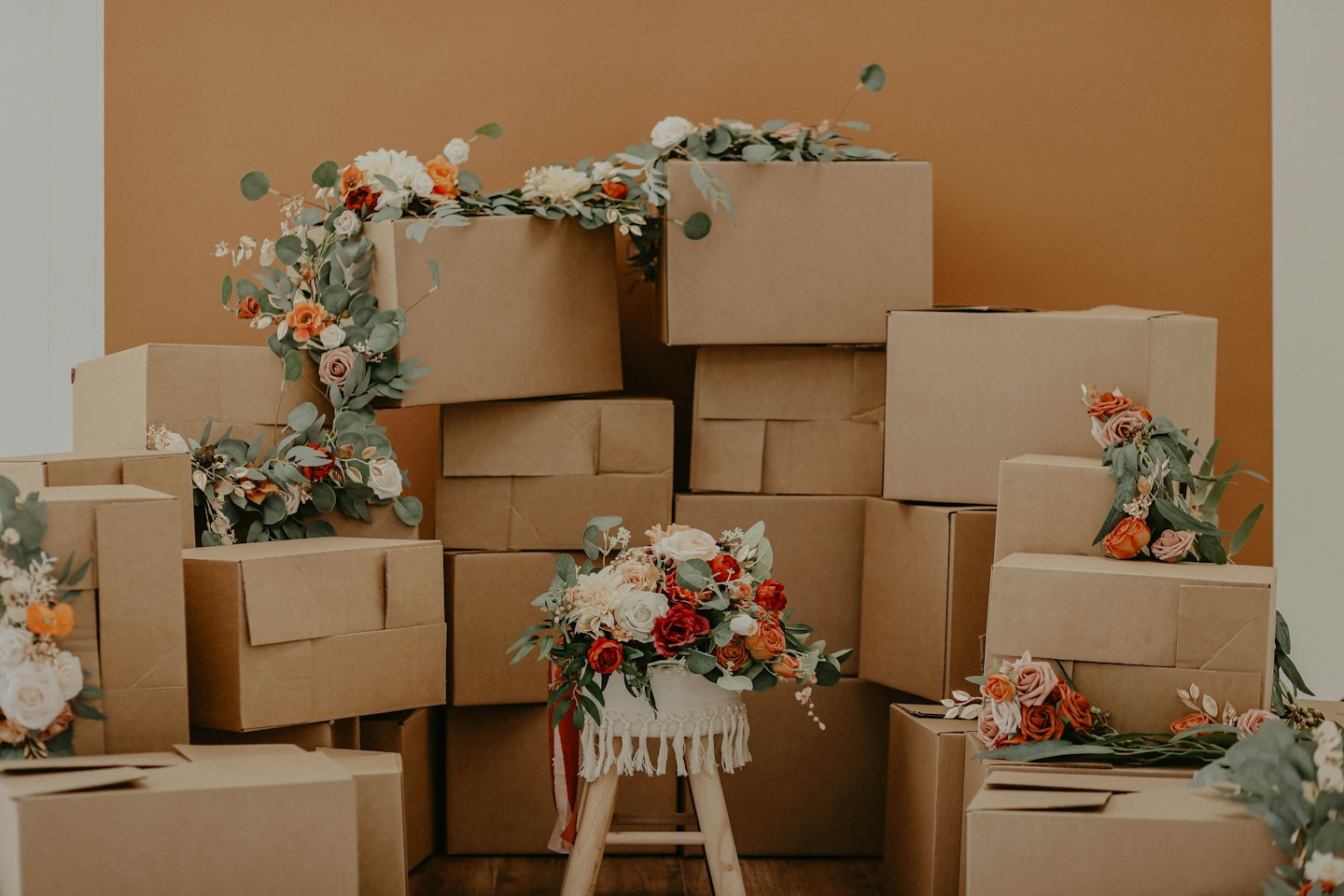 Boîtes de déménagement empilées avec des arrangements floraux dans une pièce.